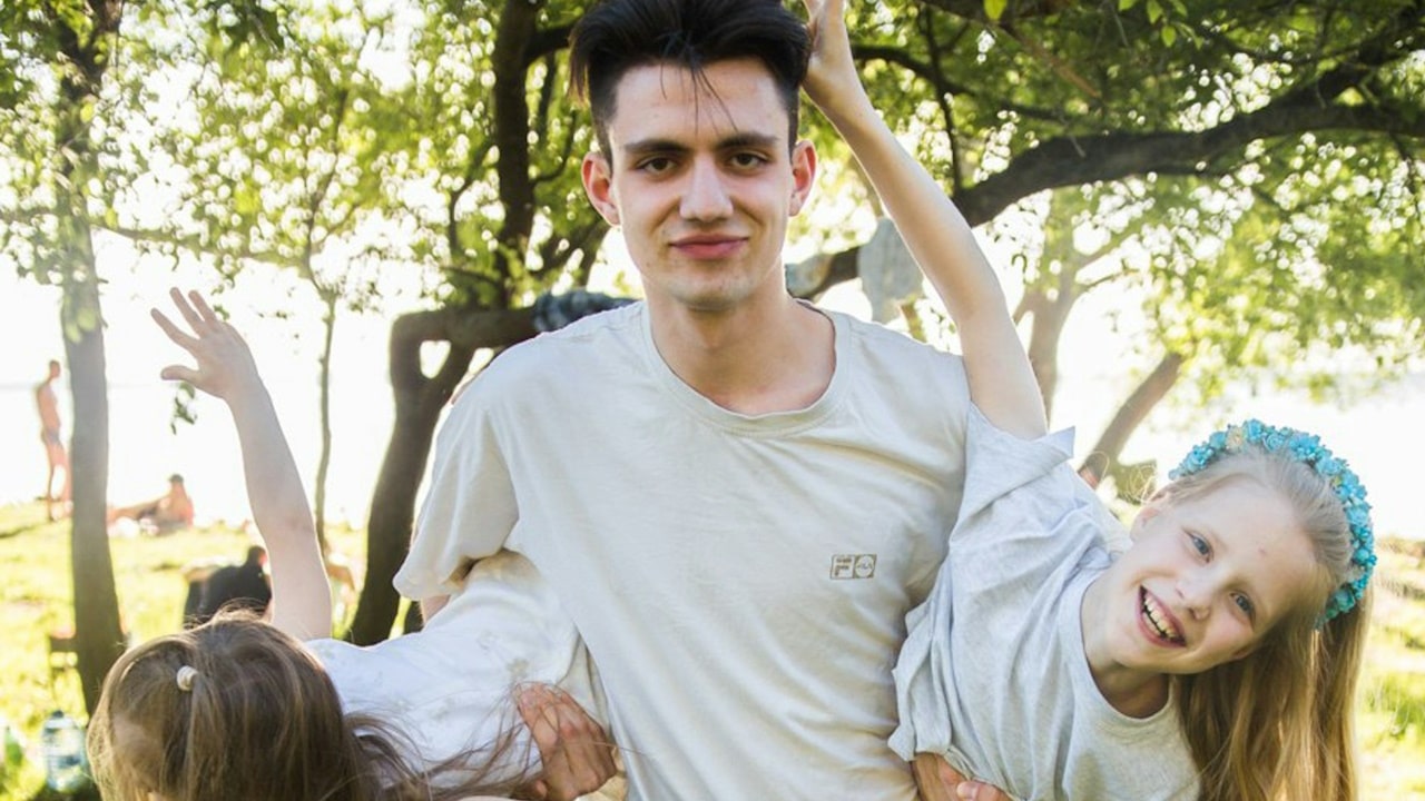 A man holding his daughters in his arms.