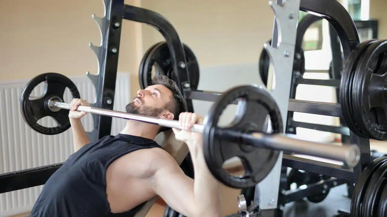 A man lifting a barbell on a bench press machine