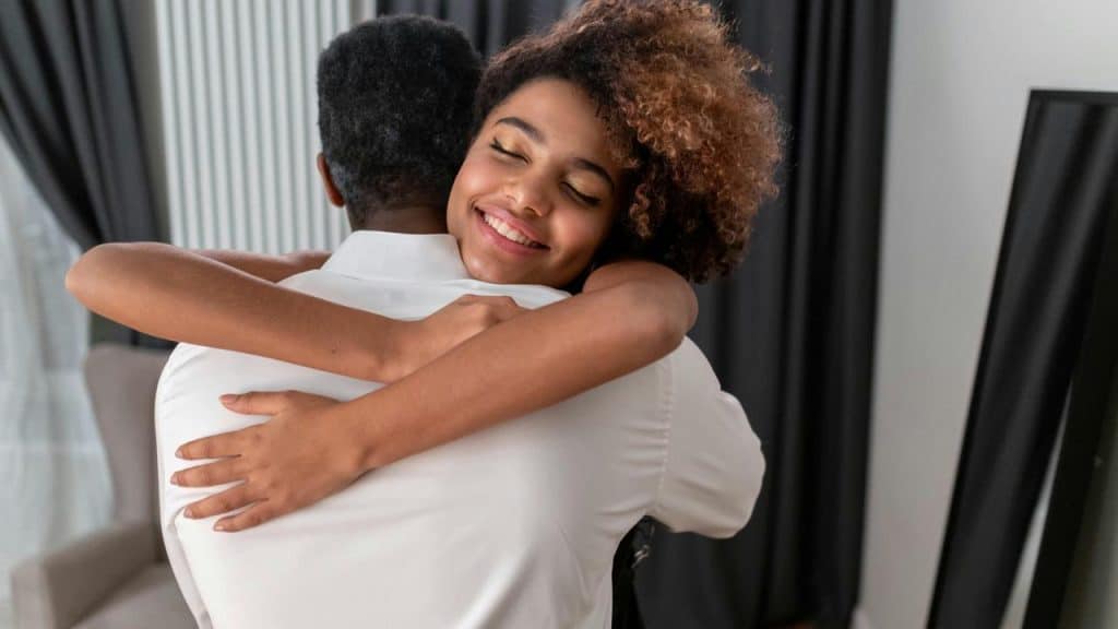 A smiling woman hugging a man