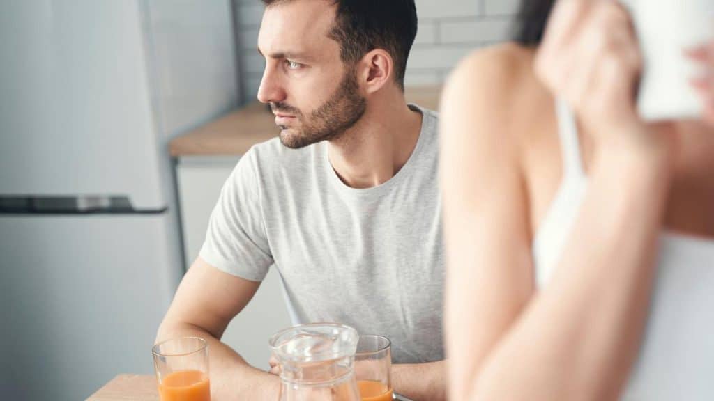 A serious man sits at a table