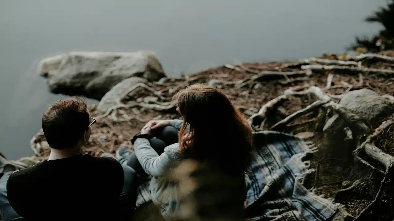 A couple talking while near a body of water