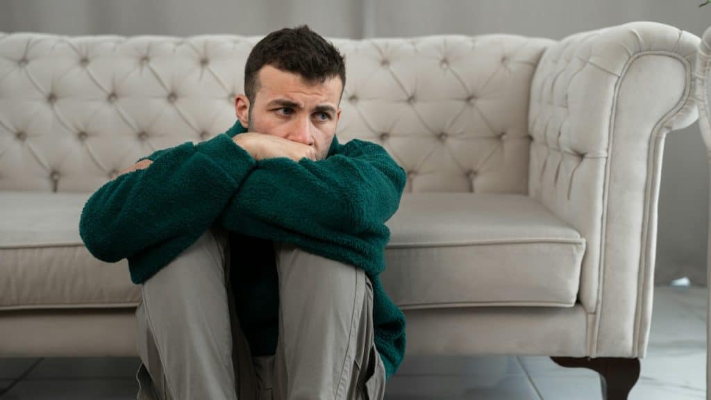 A man sitting on the floor in the living room.