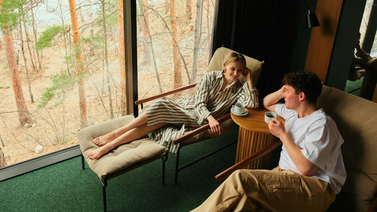 A couple relaxing with coffee by a large window