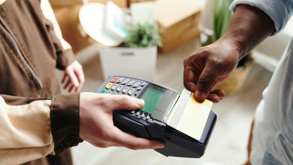 A person paying with a card at a handheld payment terminal.