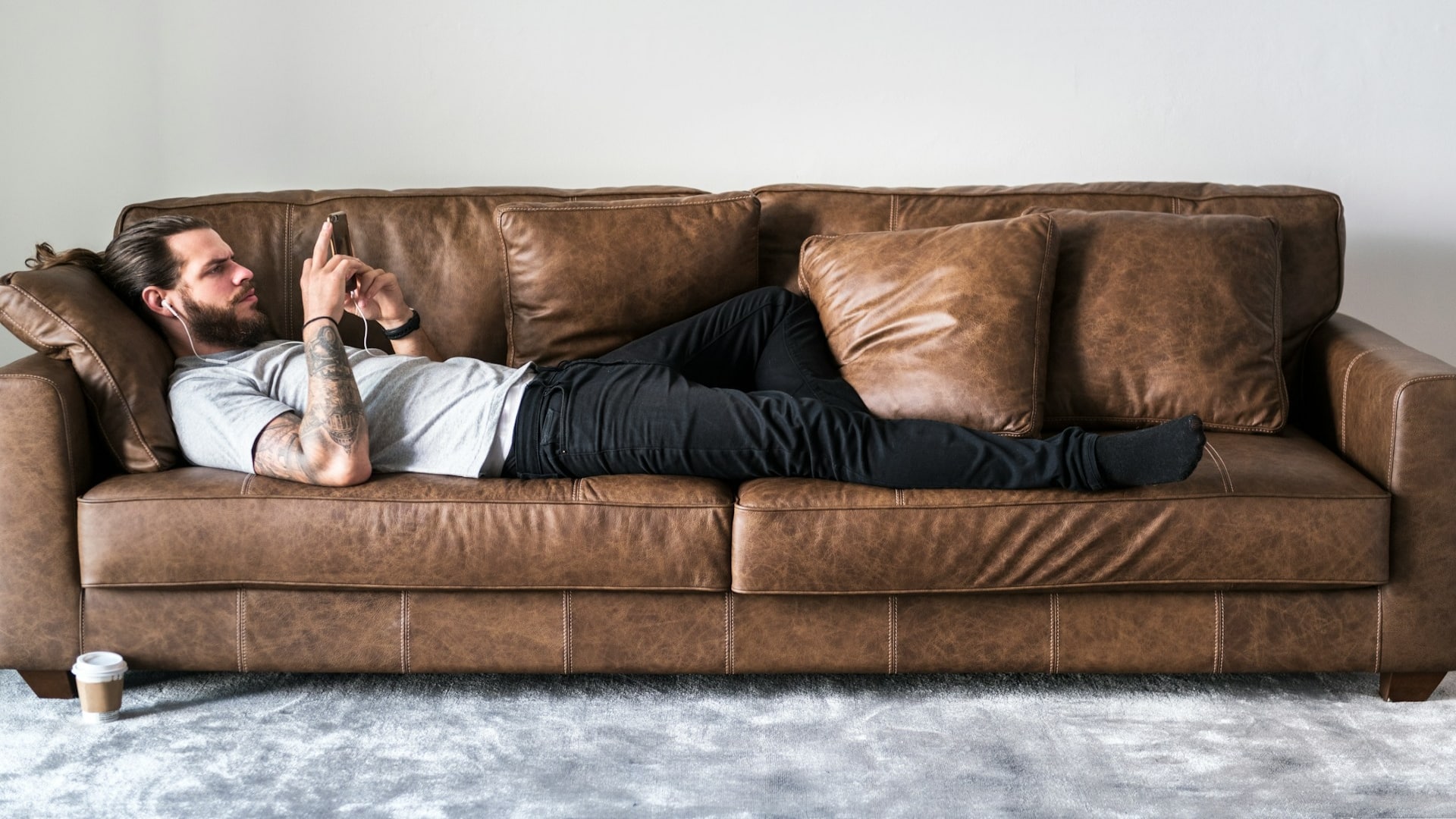 man sitting idly on couch