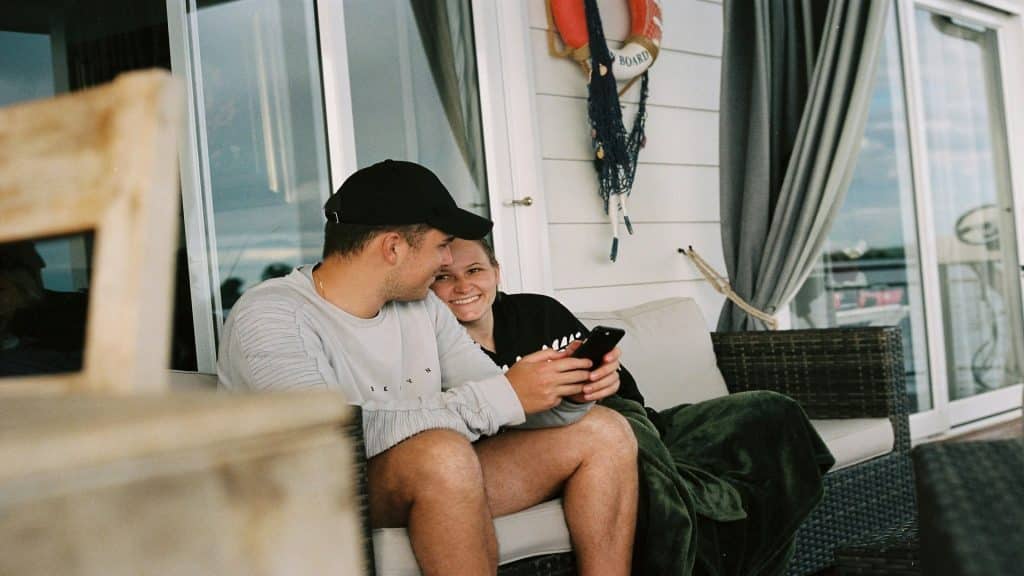 couple sitting together using phones