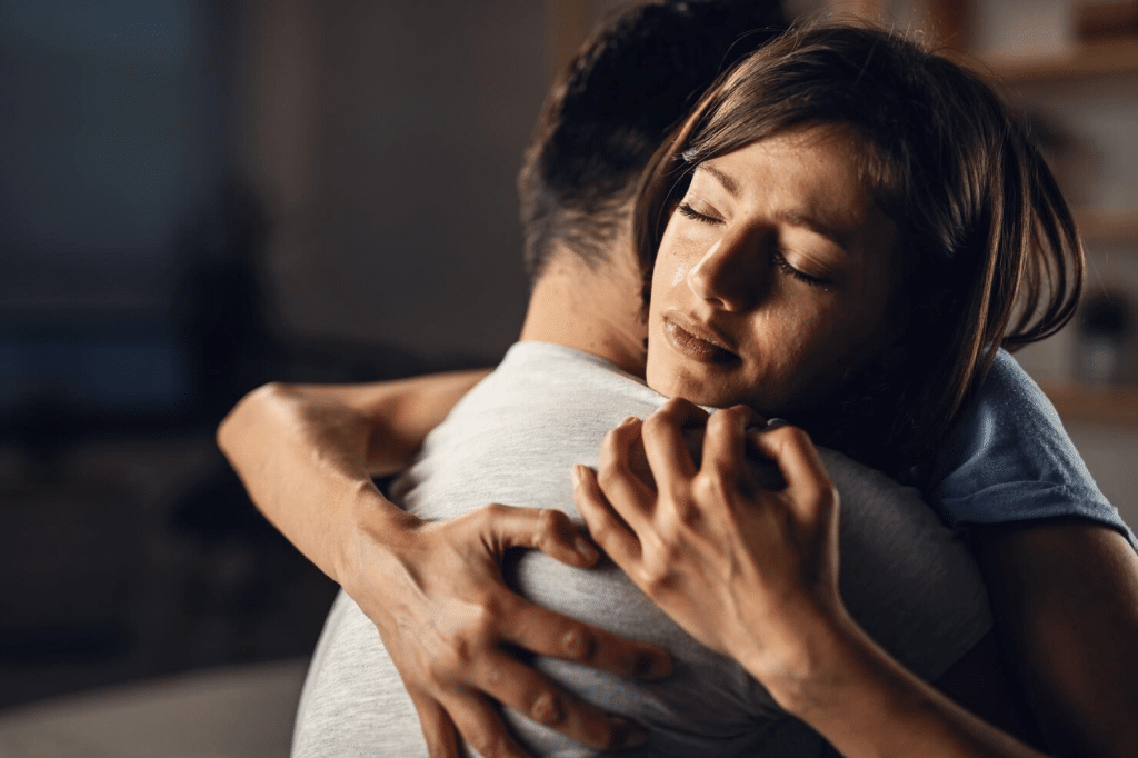 A woman hugging a man to comfort him