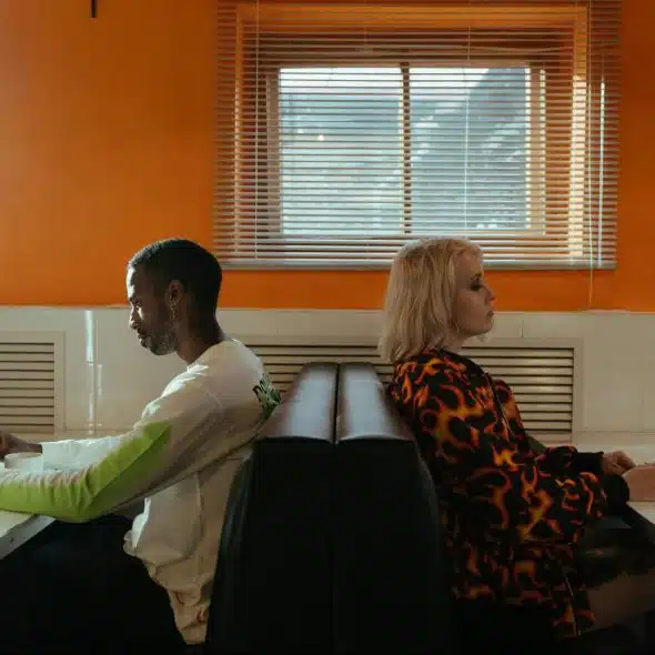 A man and woman sitting back to back