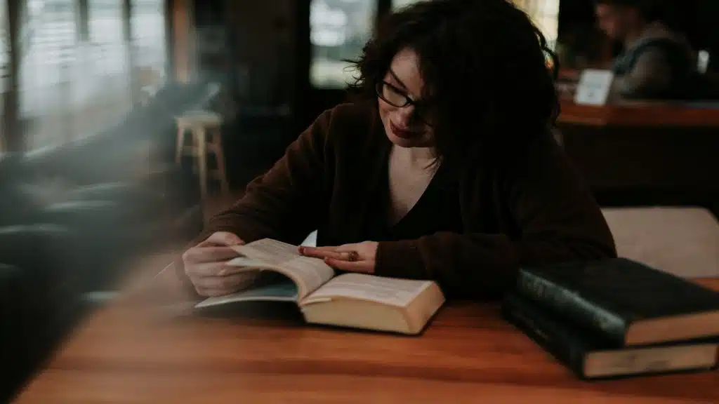 woman reading book in café