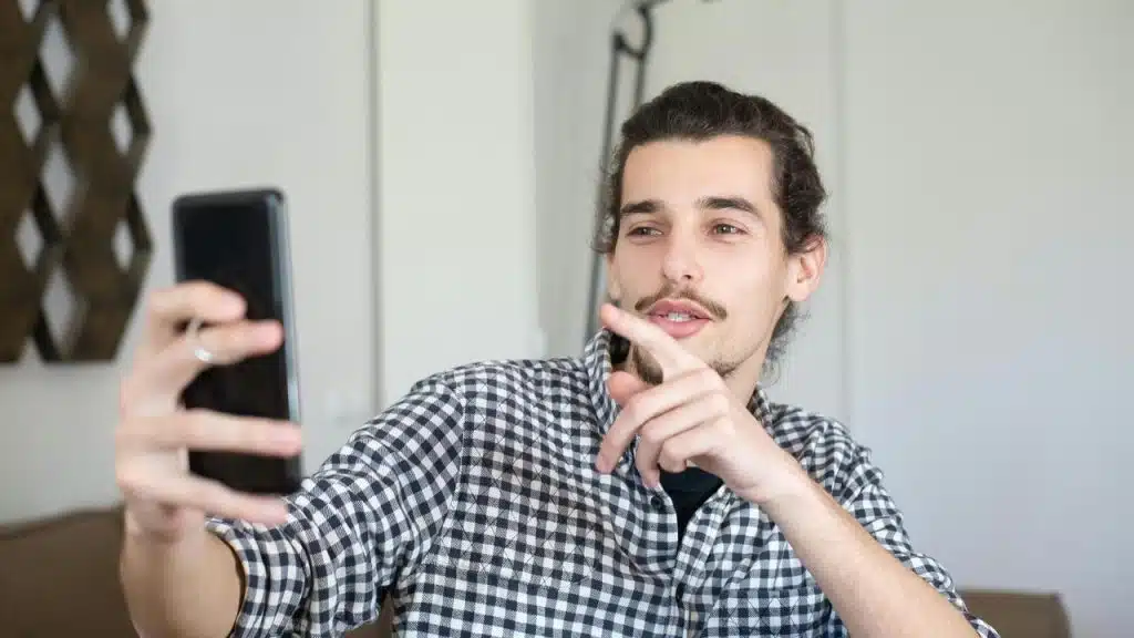 A man taking a selfie with a smartphone.