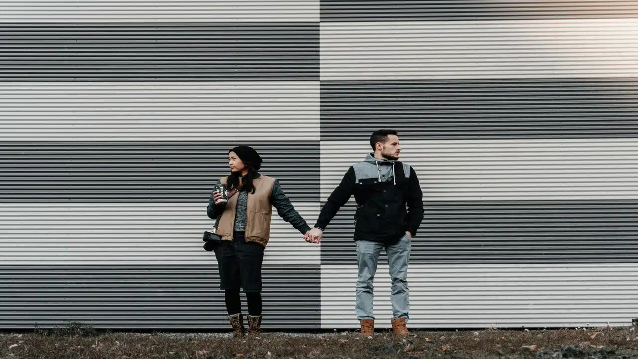 Couple holding each other’s hands but not looking at each other