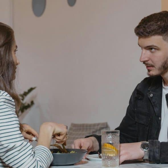 A man and woman sitting at a table having a serious conversation