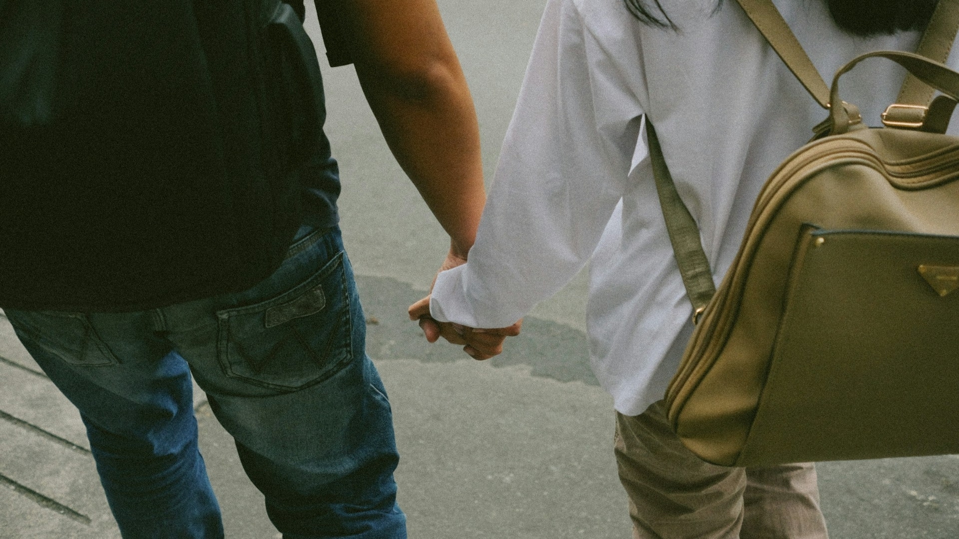 man holding partner’s hand while walking