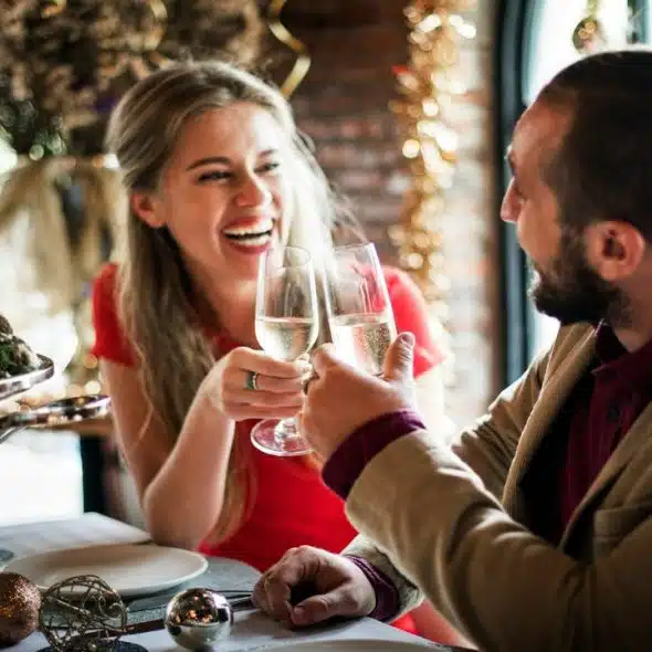 A couple toasting their glasses together