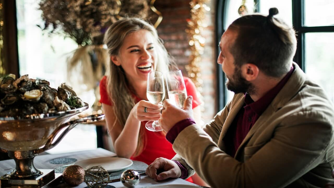 A couple toasting their glasses together