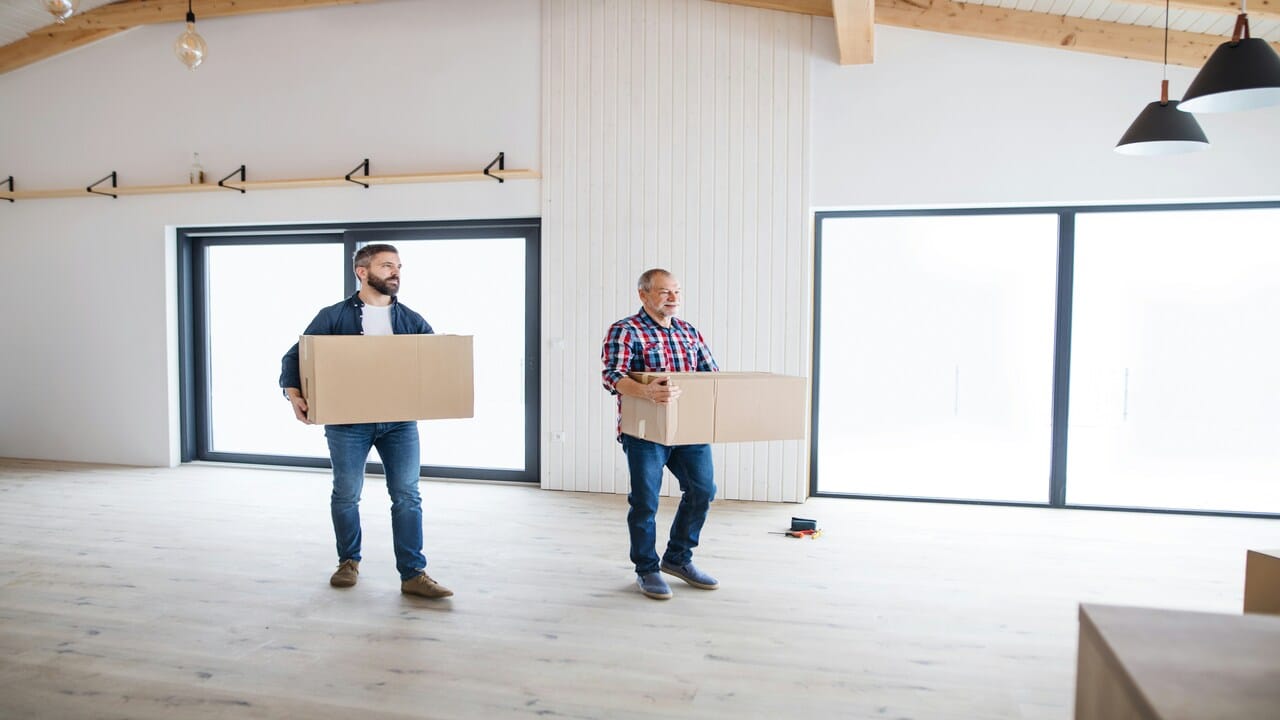 Two men carrying moving boxes