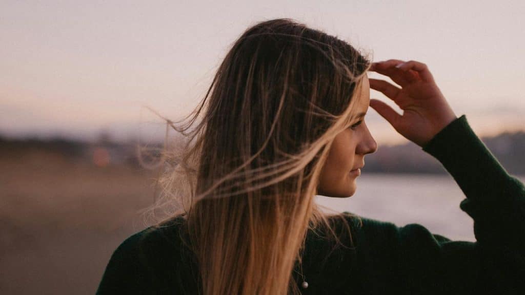 A woman looking into the distance with wind-blown hair