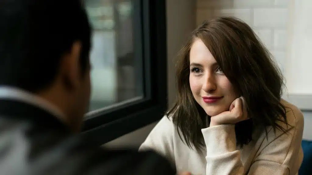 A couple looking at each other while sitting together.