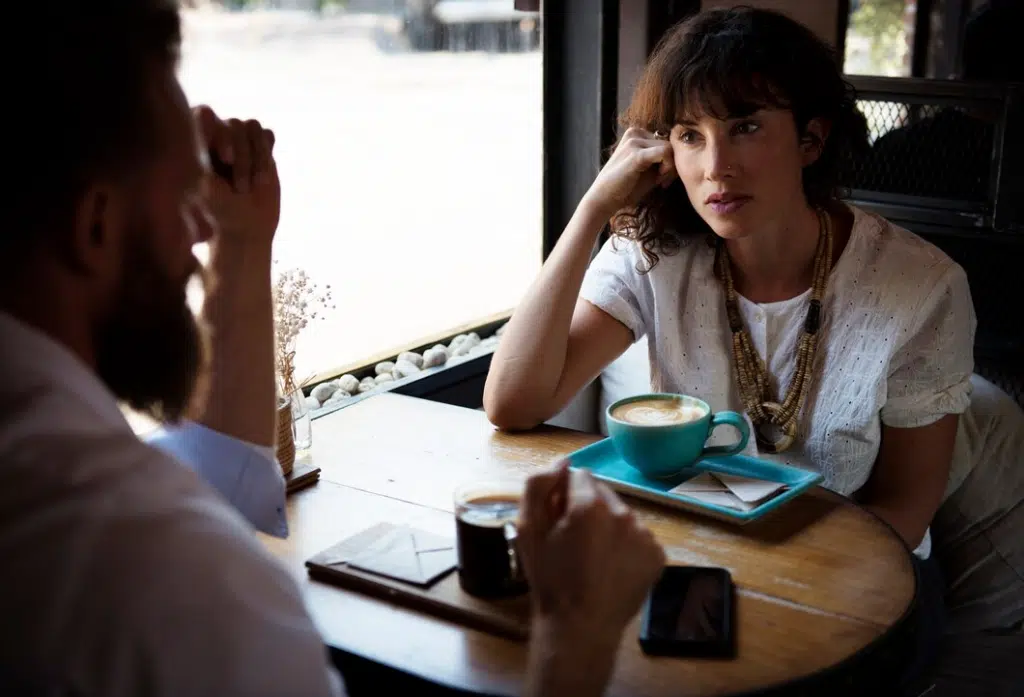 Woman in serious conversation with man inside cafe