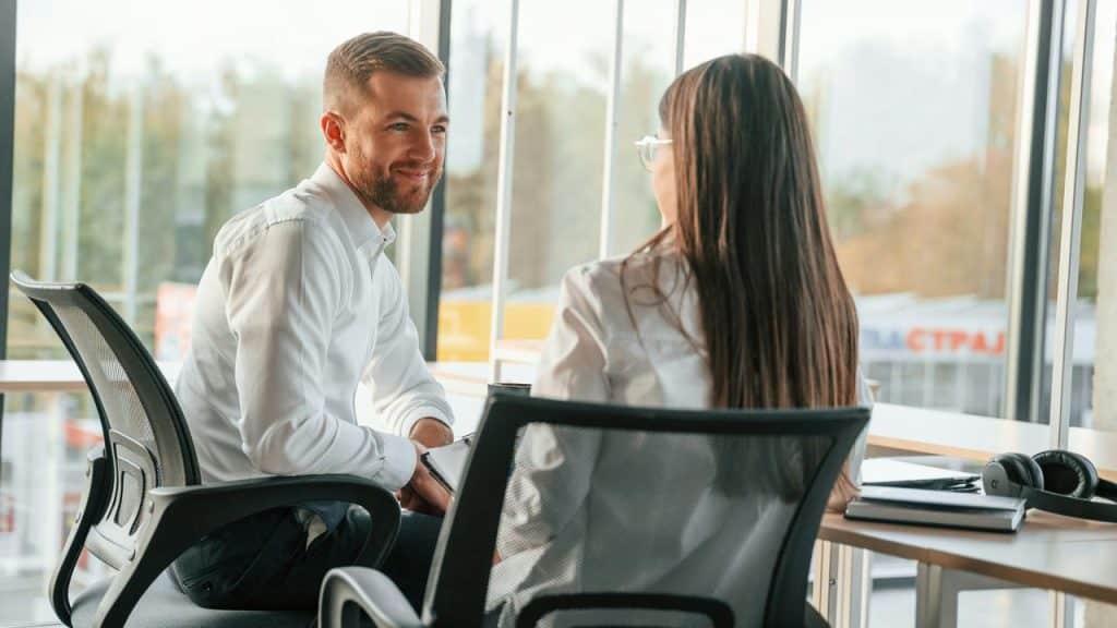A man and woman sit in an office