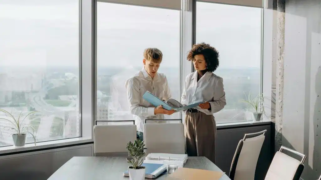 A man and woman reviewing documents in an office.