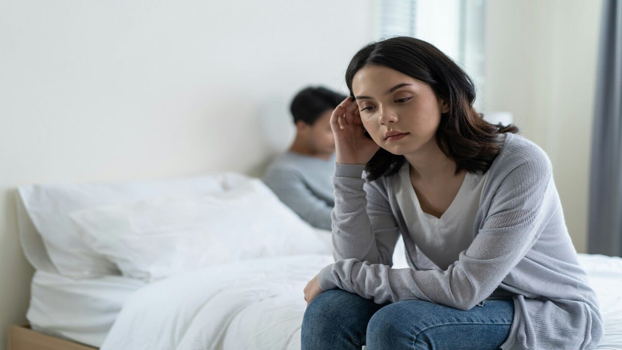 A woman looking sad in the bedroom
