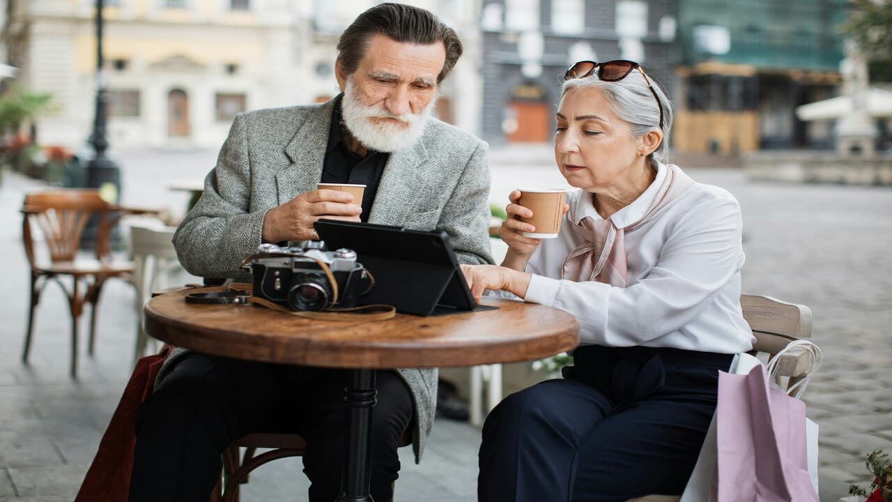 A stylish older couple looking at an iPad