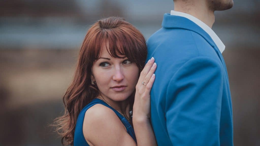 A woman holding a man from behind.