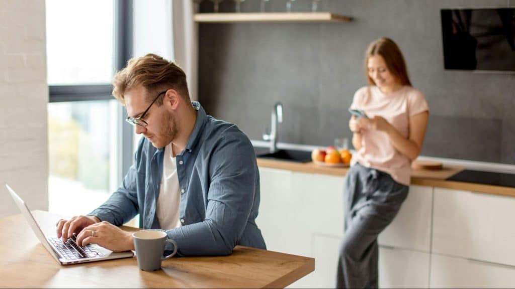 Woman busy with her phone and a man working