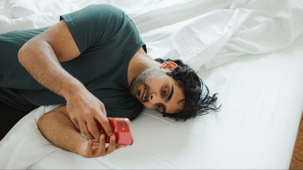 A man texting while in the bed