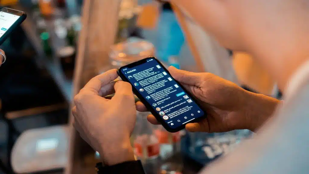 man looking at phone with multiple chats