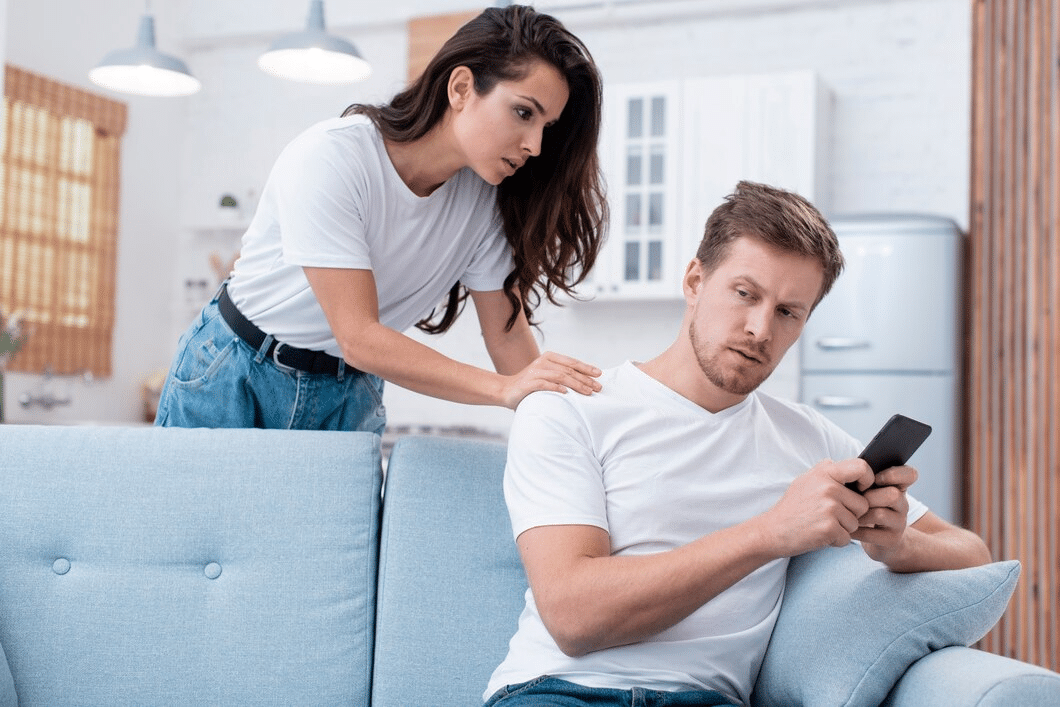 Woman arguing with man on phone sitting on sofa