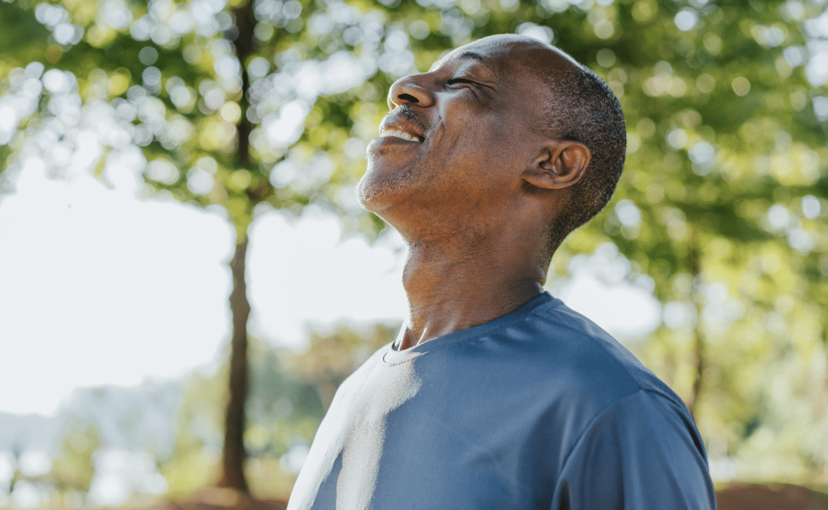 A man taking a deep breath outdoors