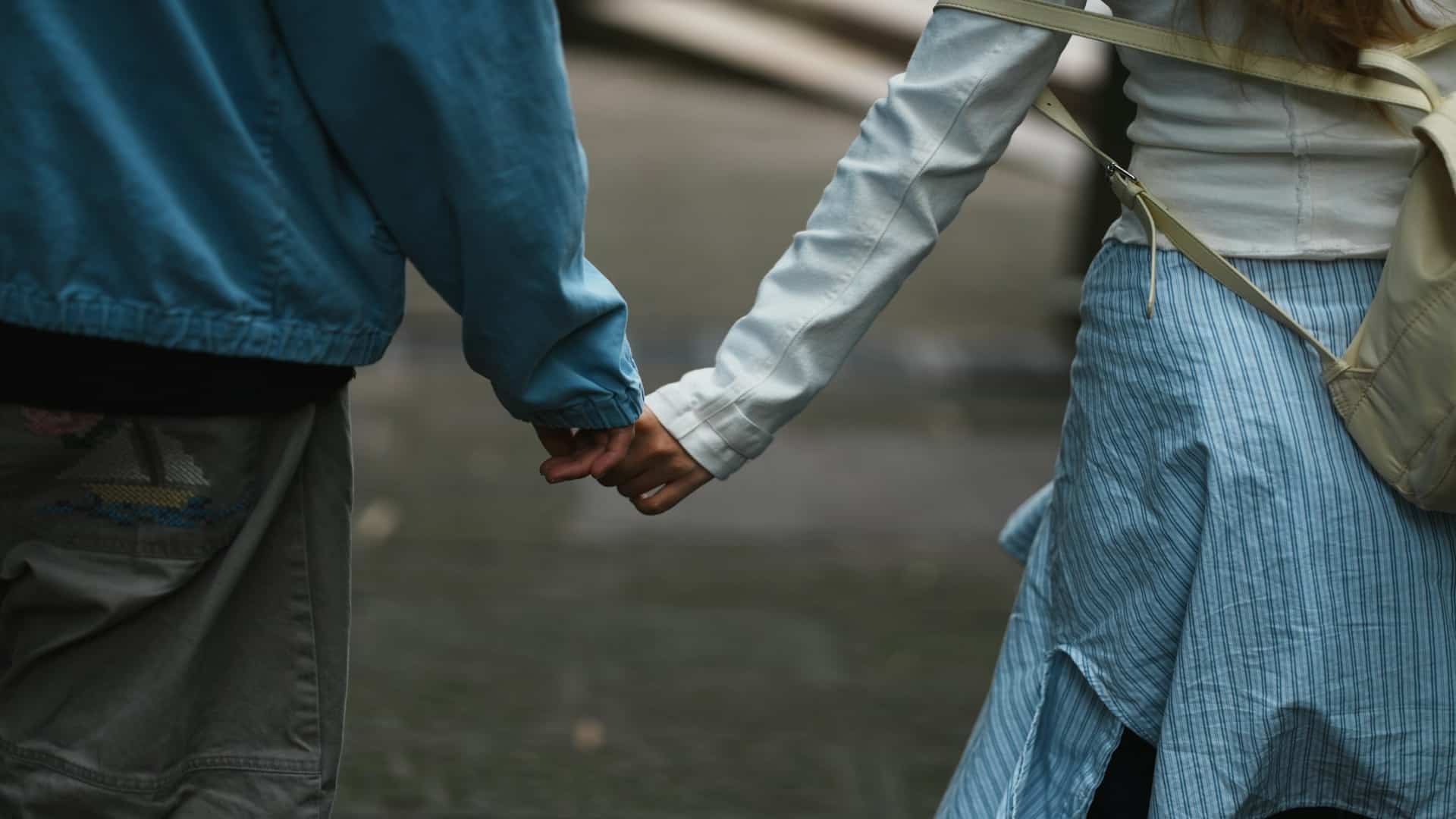 couple holding hands while walking