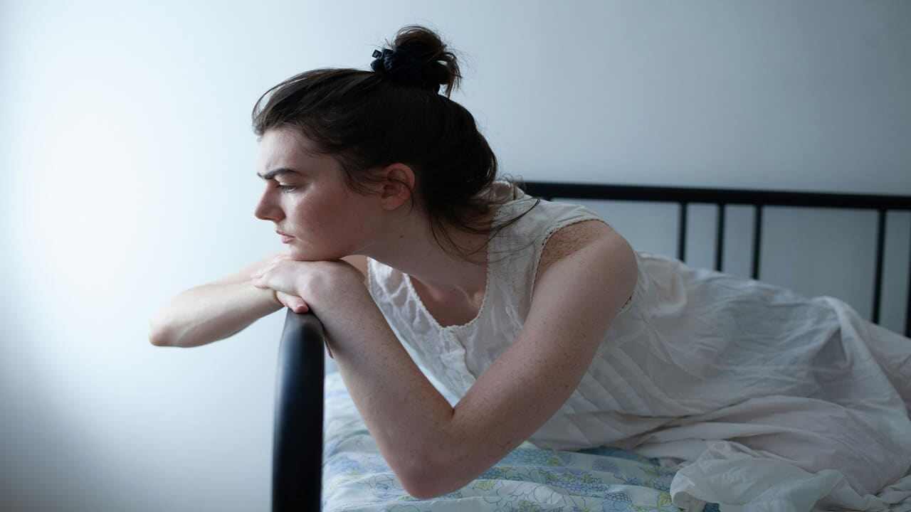 A woman looking sad at home