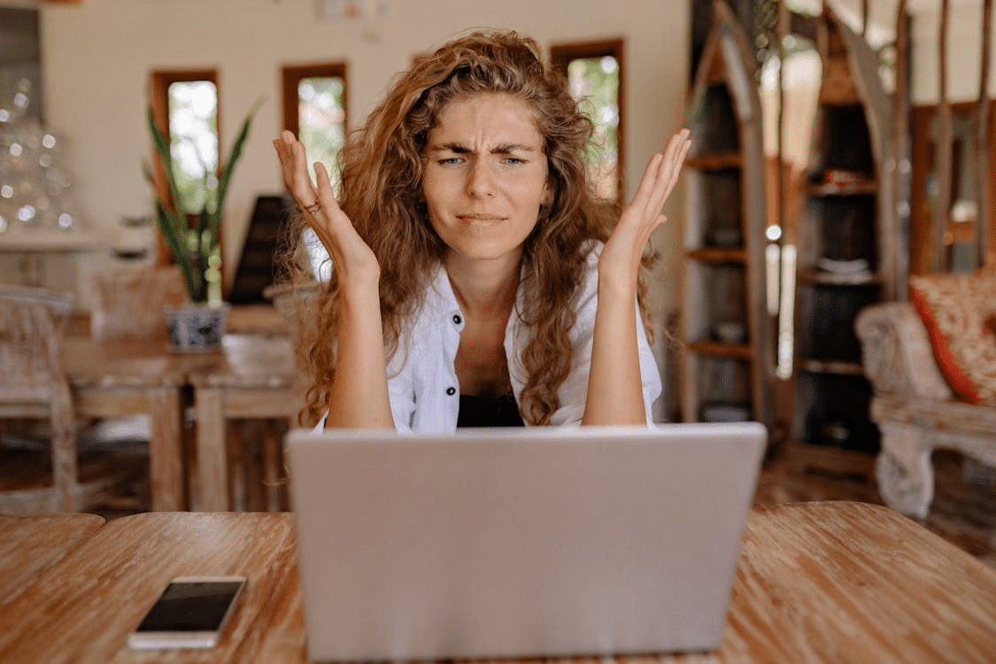 Woman in front of laptop Showing Frustrations on Her Face