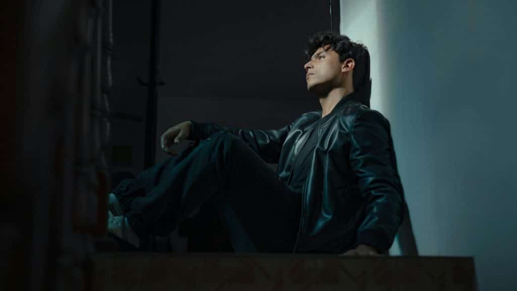 A man sitting on a ledge in a dark room.