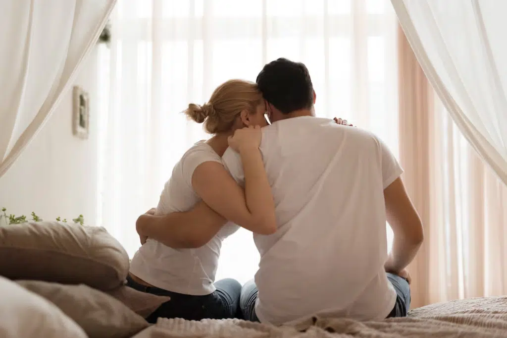 Couple in bed sitting and hugging each other