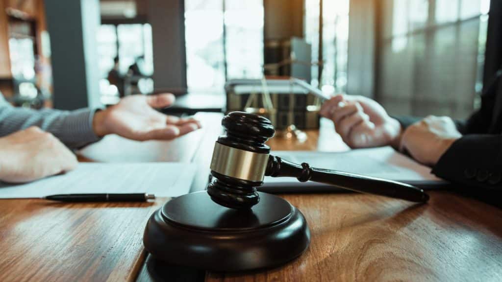 A judge's wooden gavel rests on a desk during a legal meeting.