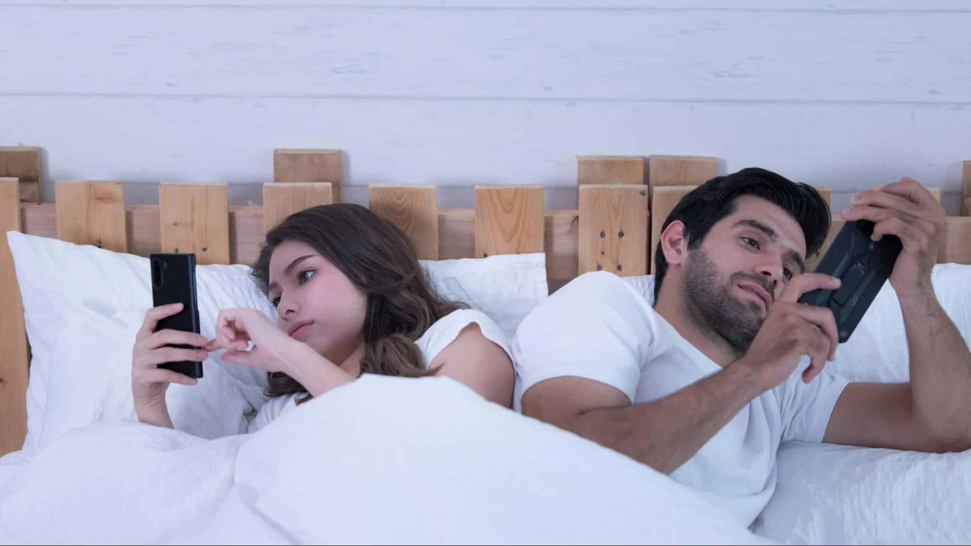 A man and woman busy with their phone