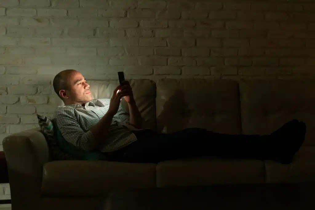man scrolling phone night