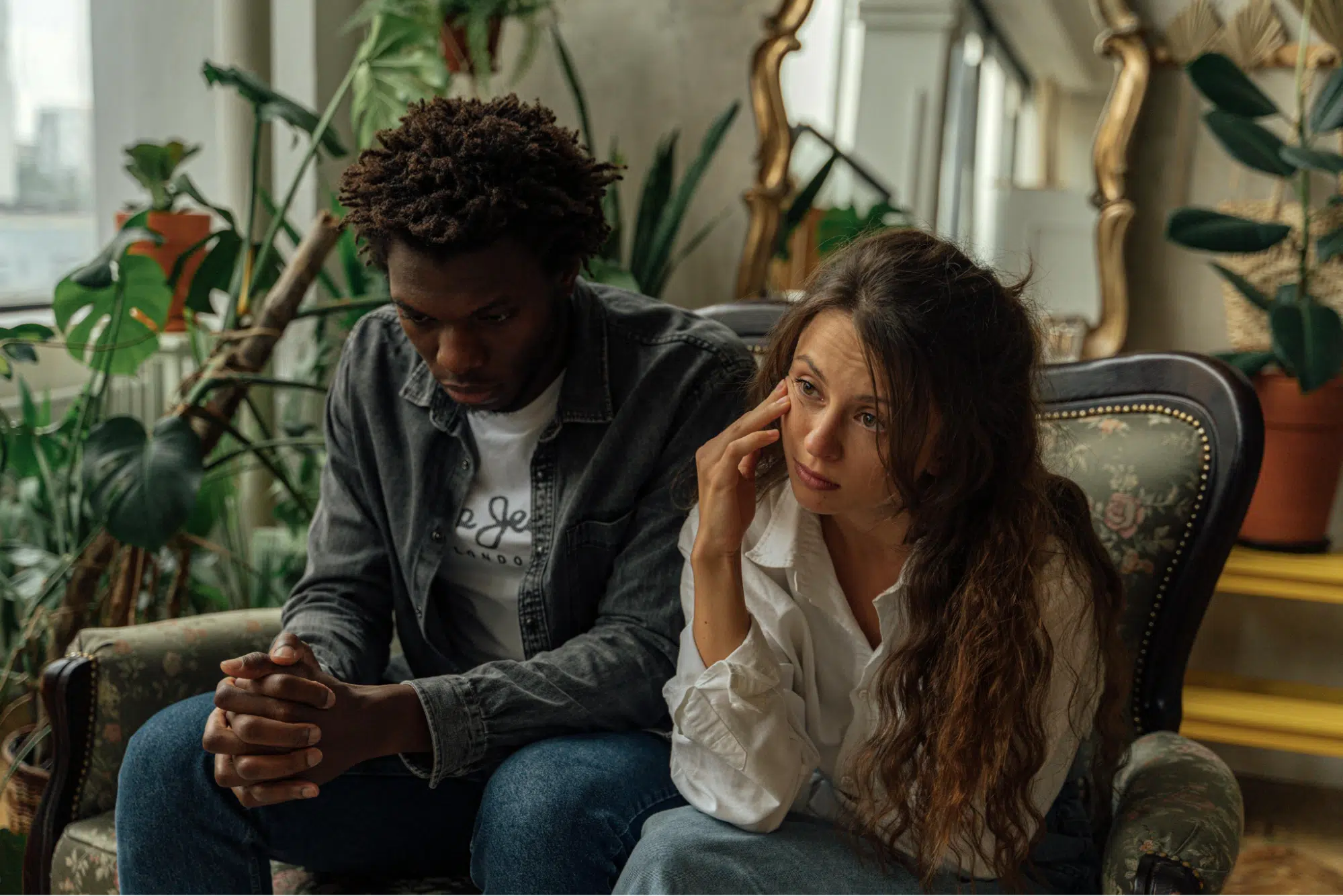 Unhappy Couple Sitting Next to Each Other on a Couch