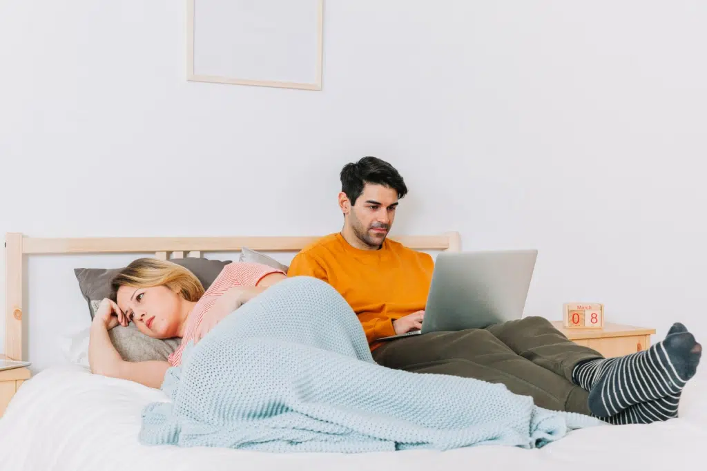A man busy working and a woman waiting for him