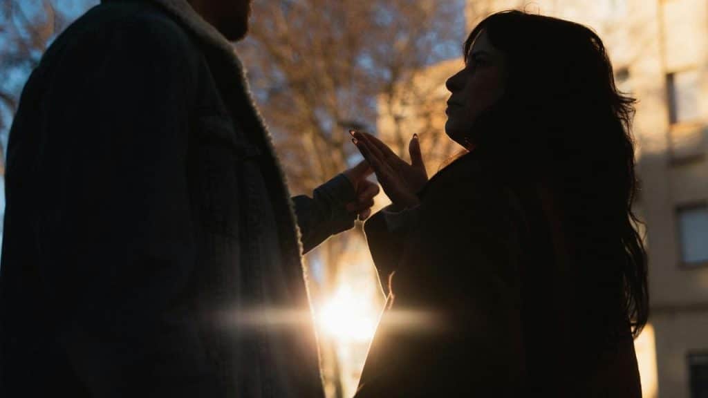 A silhouetted couple arguing outdoors