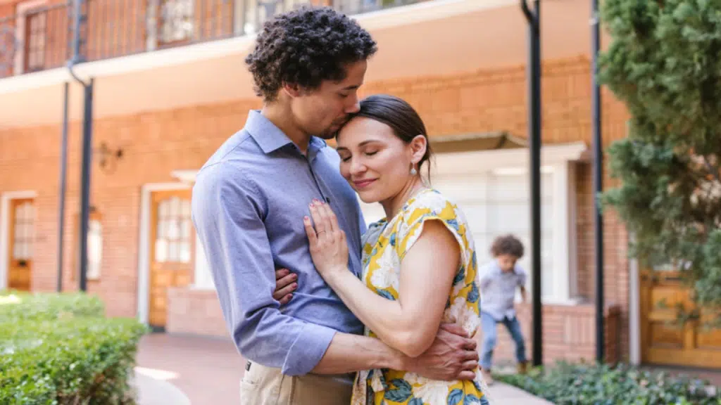 A man giving his wife a forehead kiss