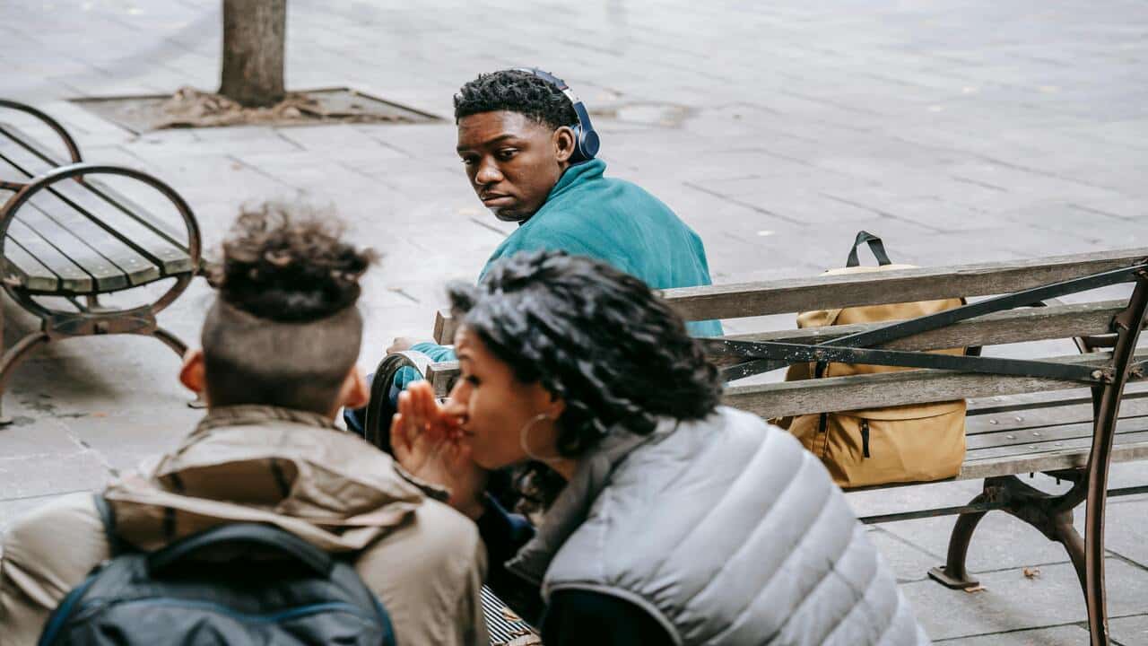 A man looking at his girlfriend gossiping