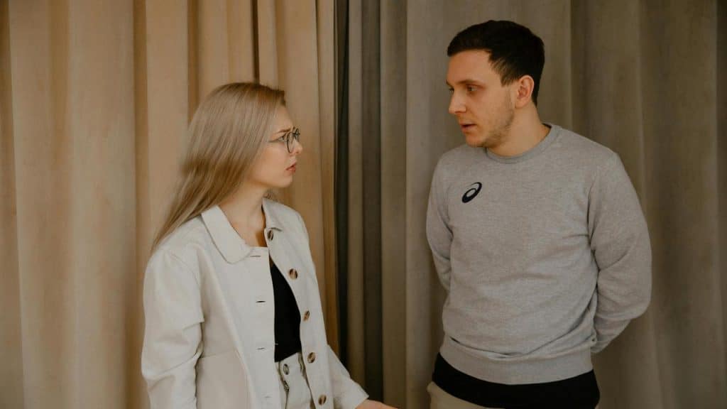 A man and woman having a serious conversation indoors.