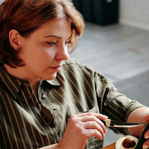 A woman cutting an avocado