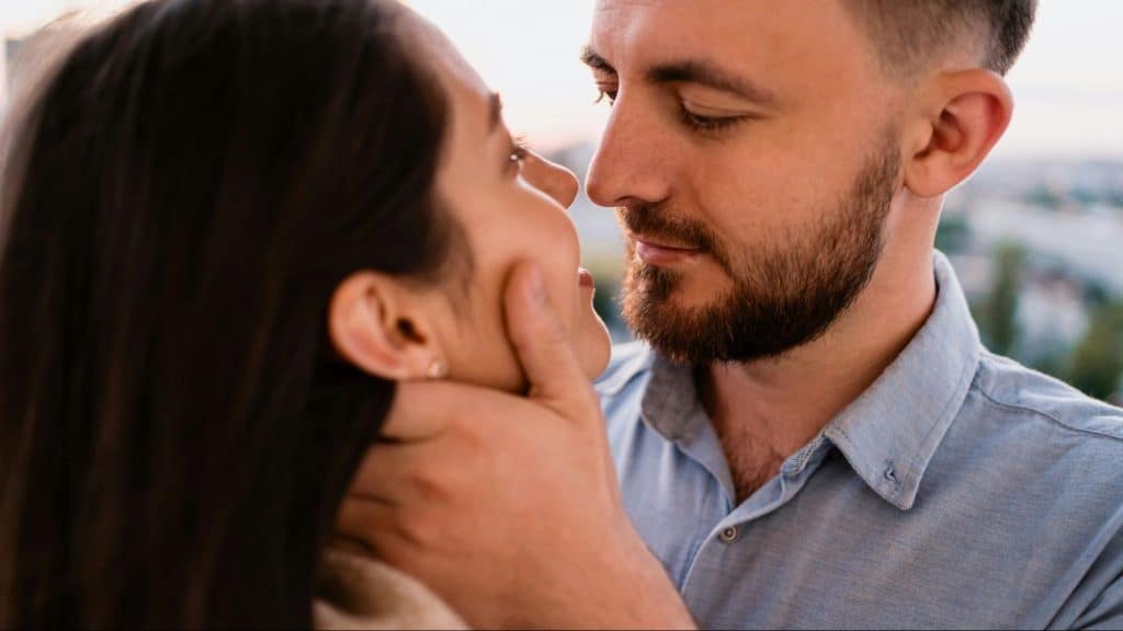 A man holding woman’s face