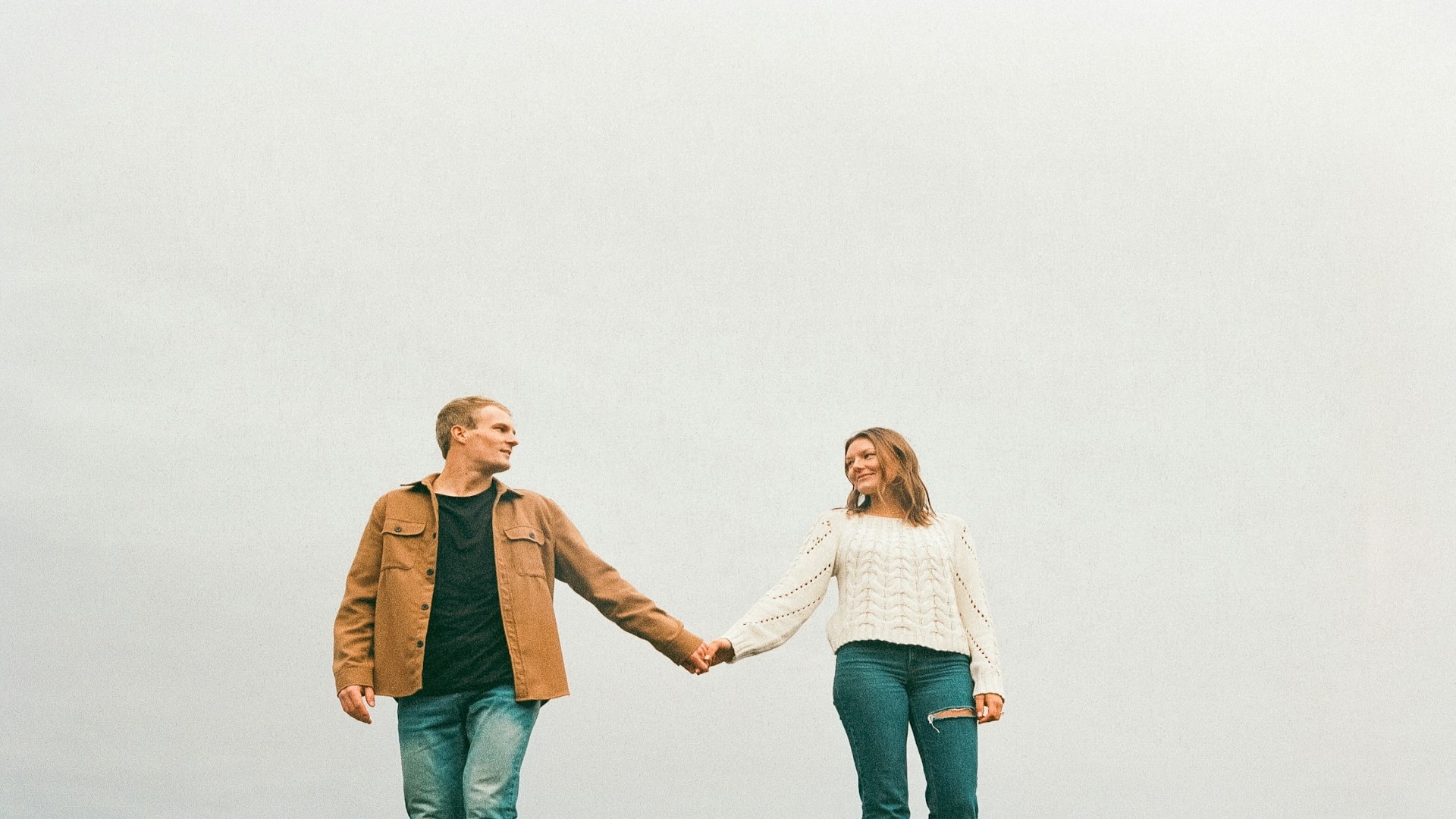 couple holding hands while walking